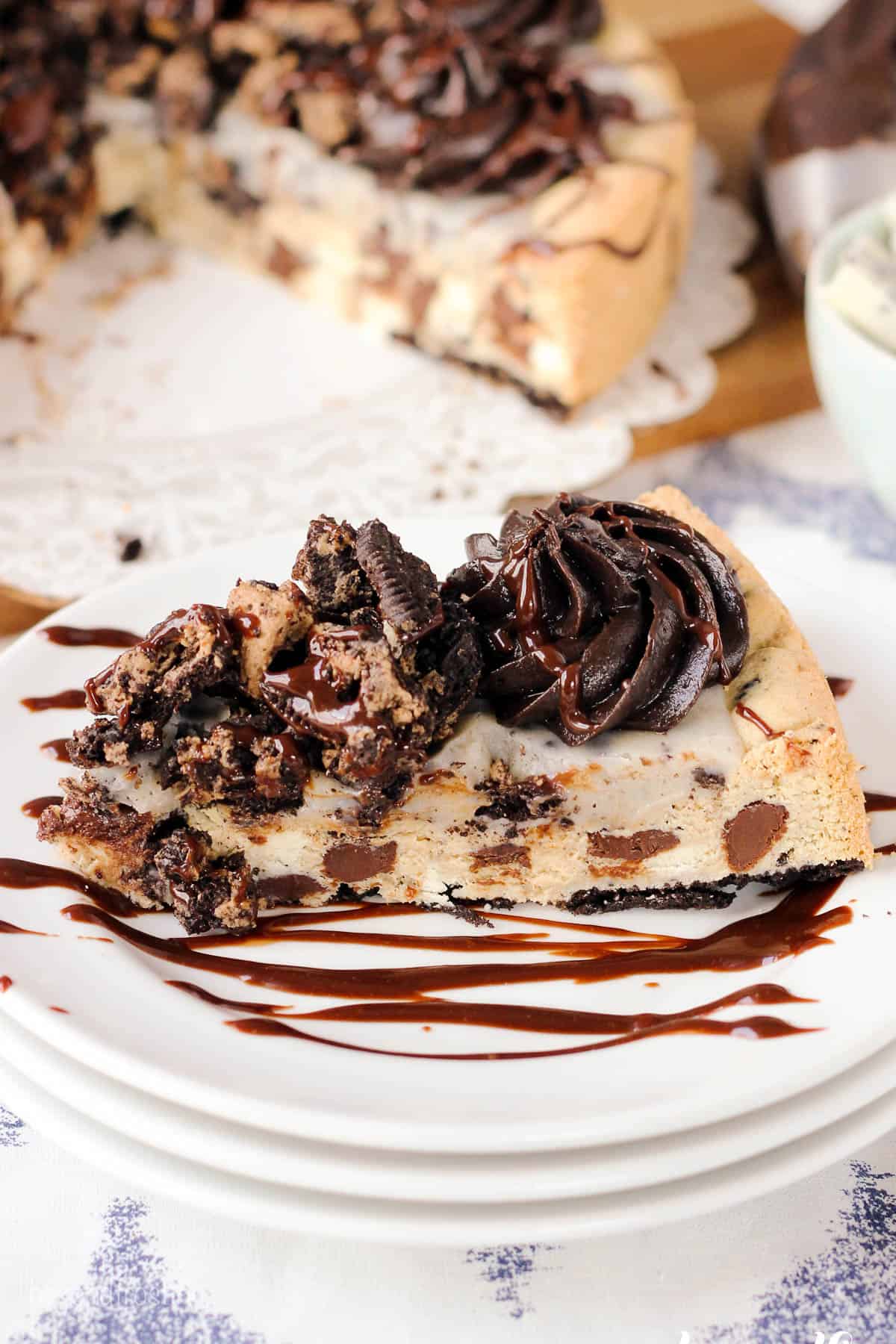 overhead of a slice of cookie cake on a plate with the cookie cake in the background