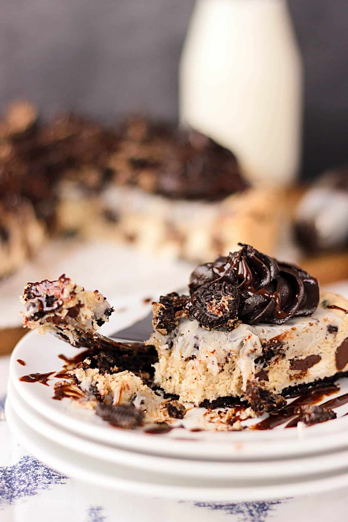 a slice of cookies and cream cake on a plate with bites taken out