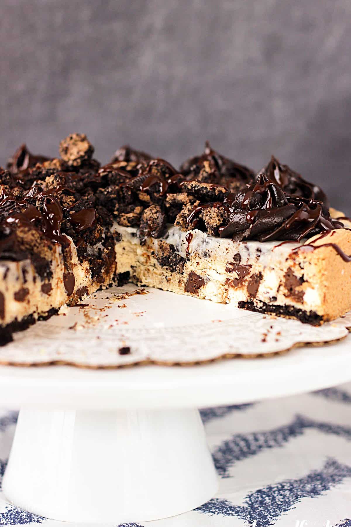 a cookie cake on a cake stand with some slices cut out