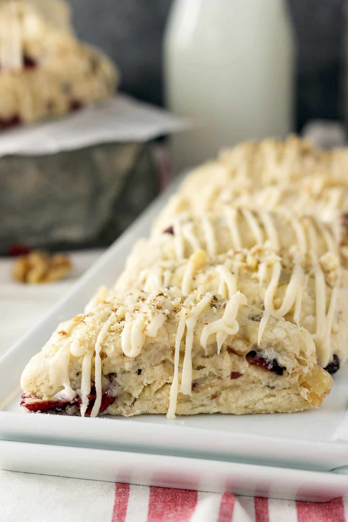 side view of a white plate lined with cranberry walnut scones