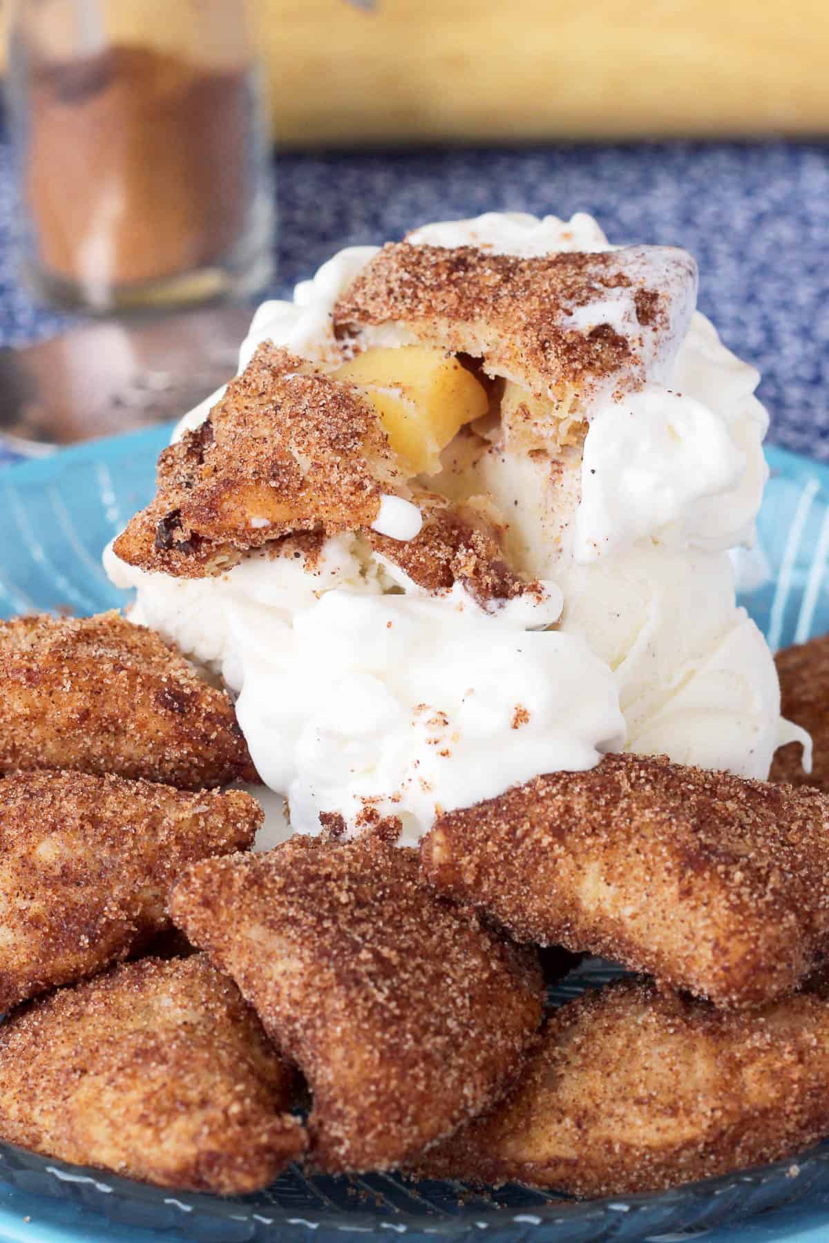 pile of apple pie bites on a plate with a scoop of ice cream