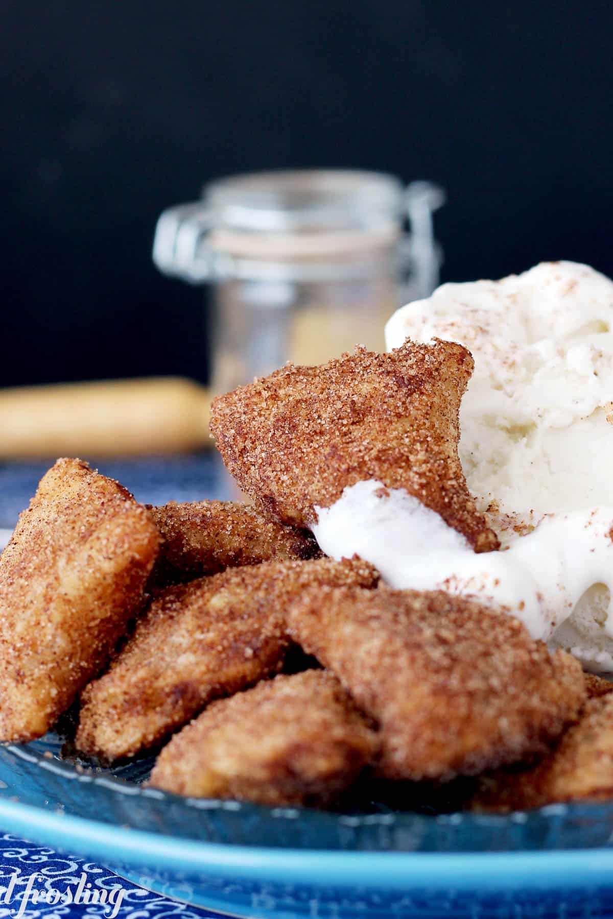 apple pie bites on a plate with a scoop of vanilla ice cream