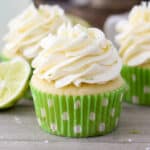 A close up of a frosted margarita cupcake in a green cupcake liner