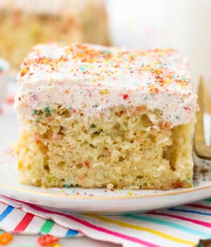 A slice of Fruity Pebble Cake with Fruity Pebble Whipped Cream