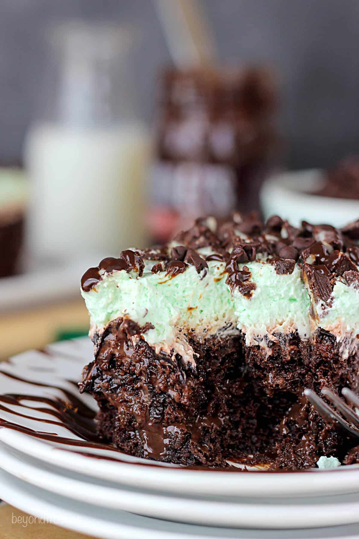 side view of a slice of mint chocolate poke cake with a bite taken out
