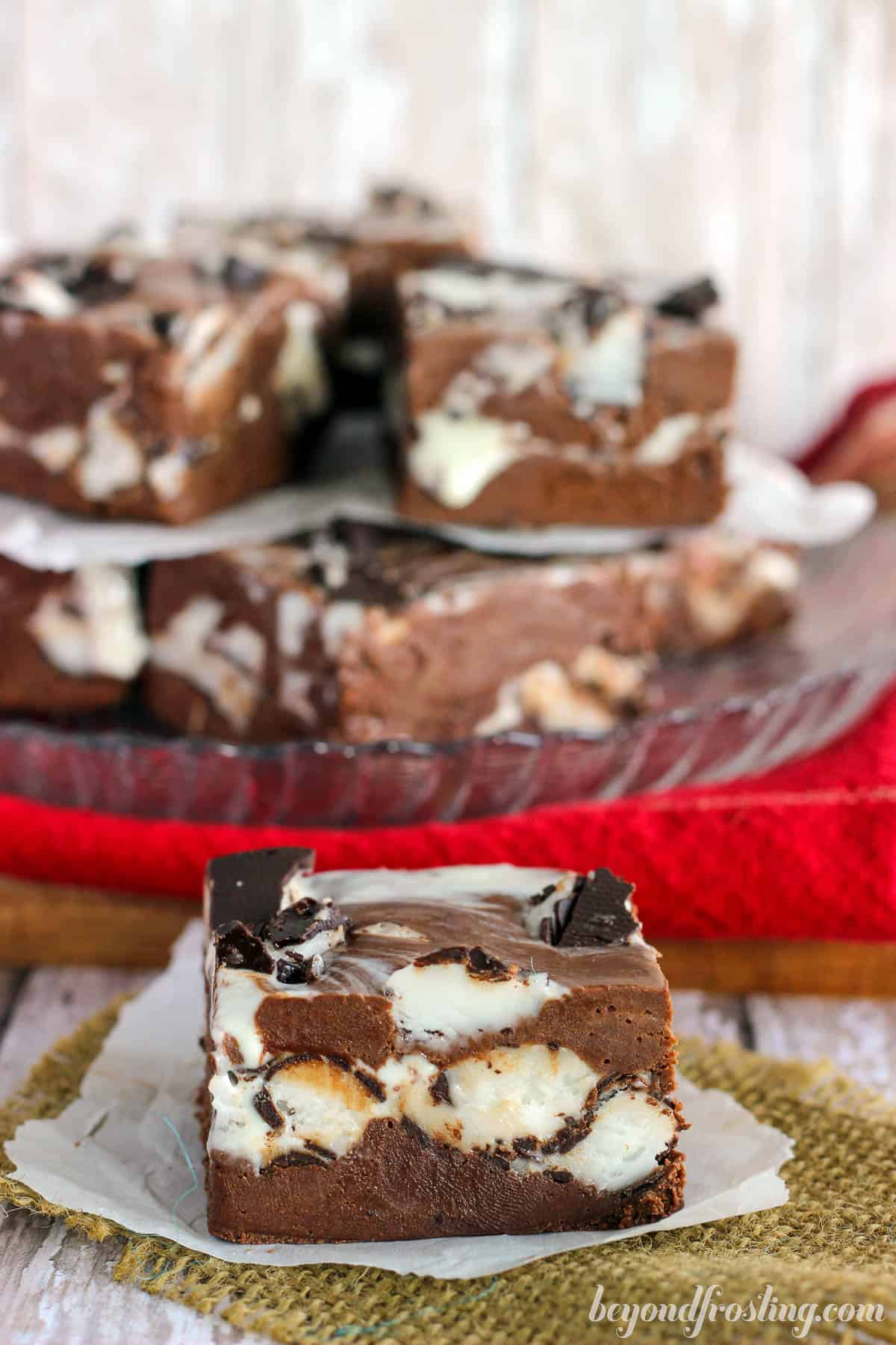 one piece of peppermint patty fudge in front of a platter with more fudge