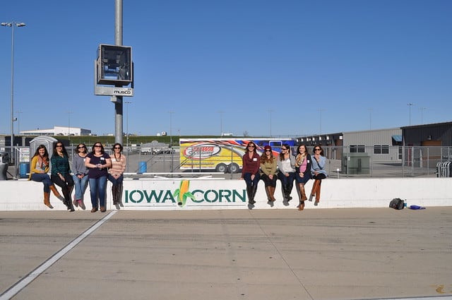 A group of ladies sitting near the Iowa Corn sign at the Iowa Speedway