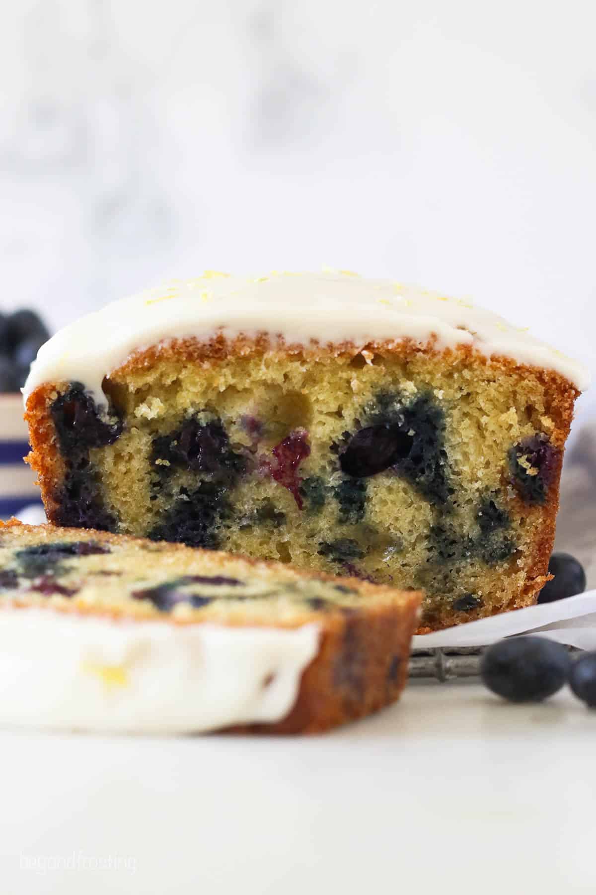 A loaf of blueberry bread slice in half to show the inside