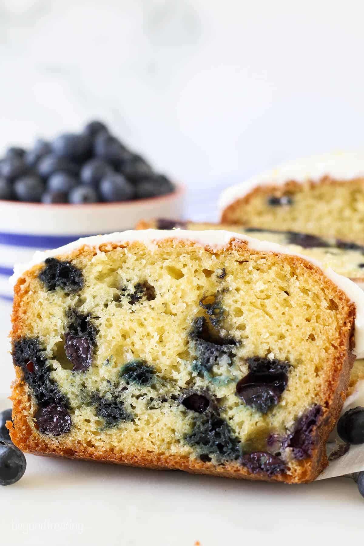 Sliced lemon bread with blueberries and glaze