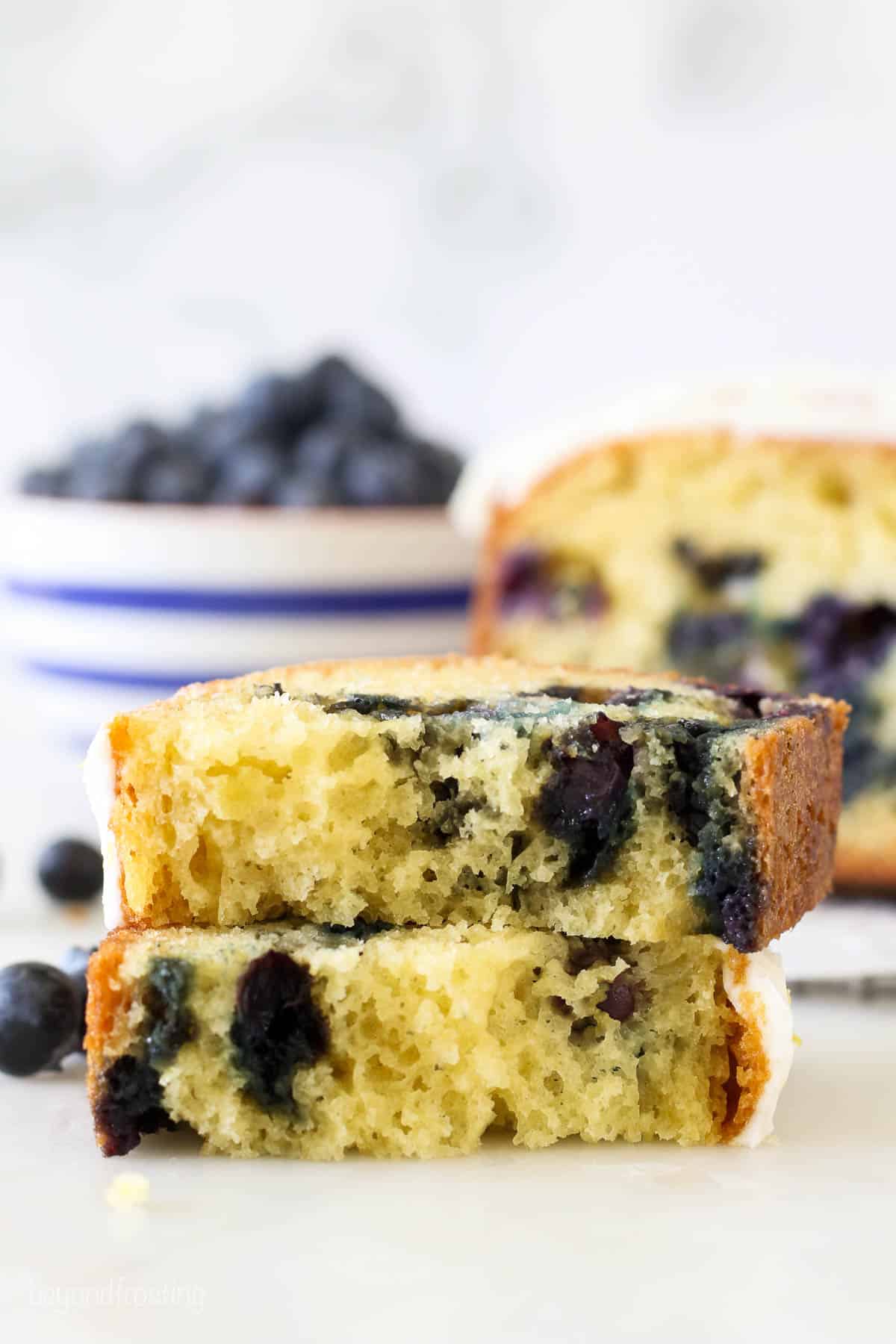 A slice of blueberry bread broken in half to show the inside of the bread
