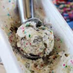 closeup overhead of a an ice cream scoop in a tub of cake batter ice cream