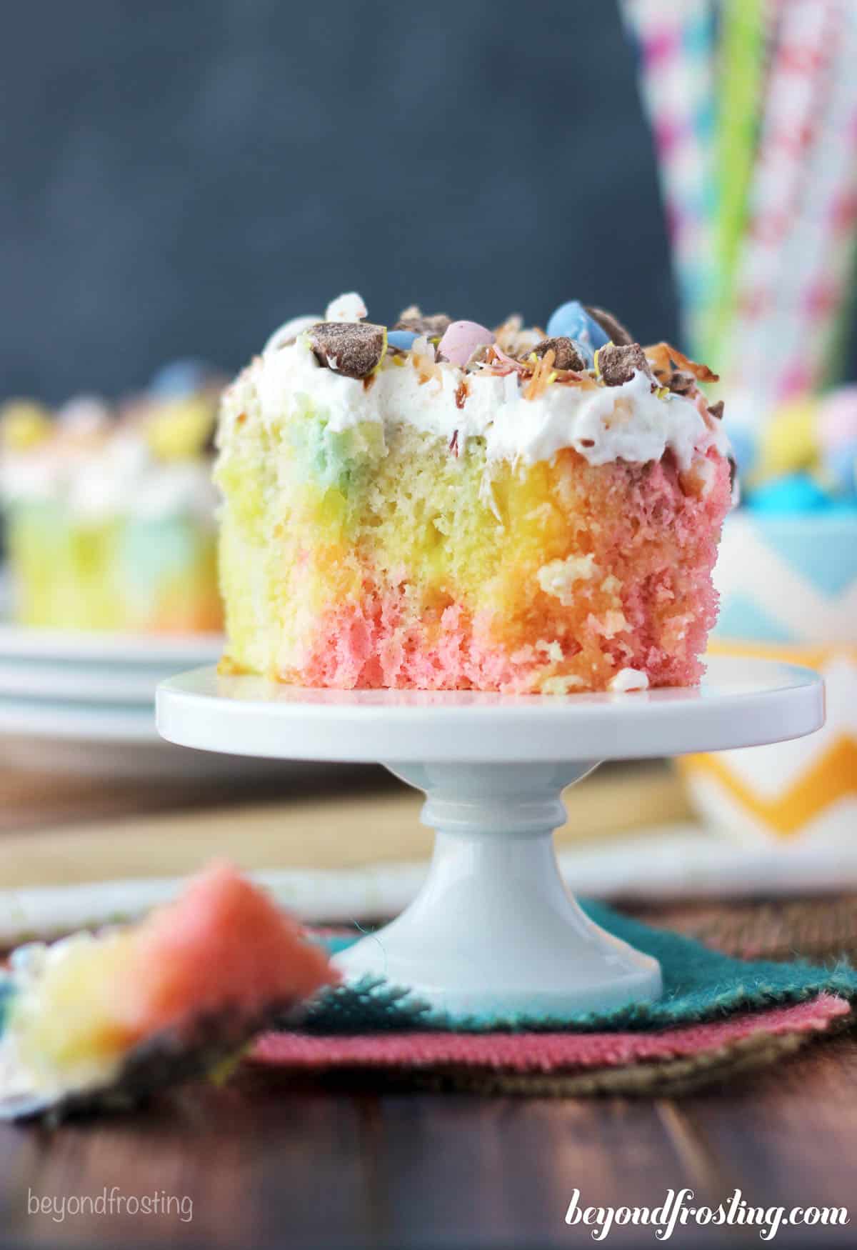 side view of a cake stand topped with a slice of tie-dye cake