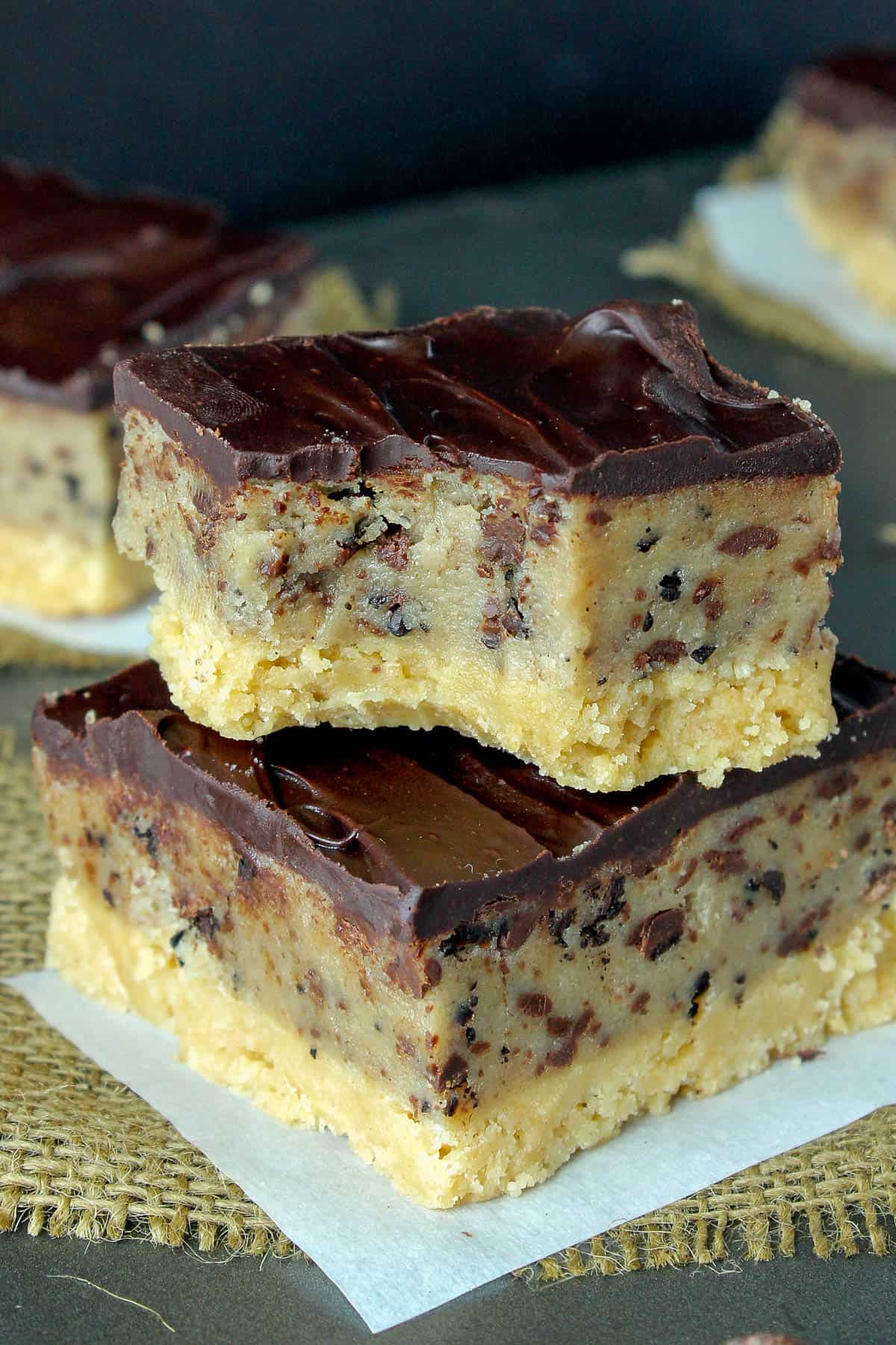 two cookie dough bars stacked with a bite taken out of the top one
