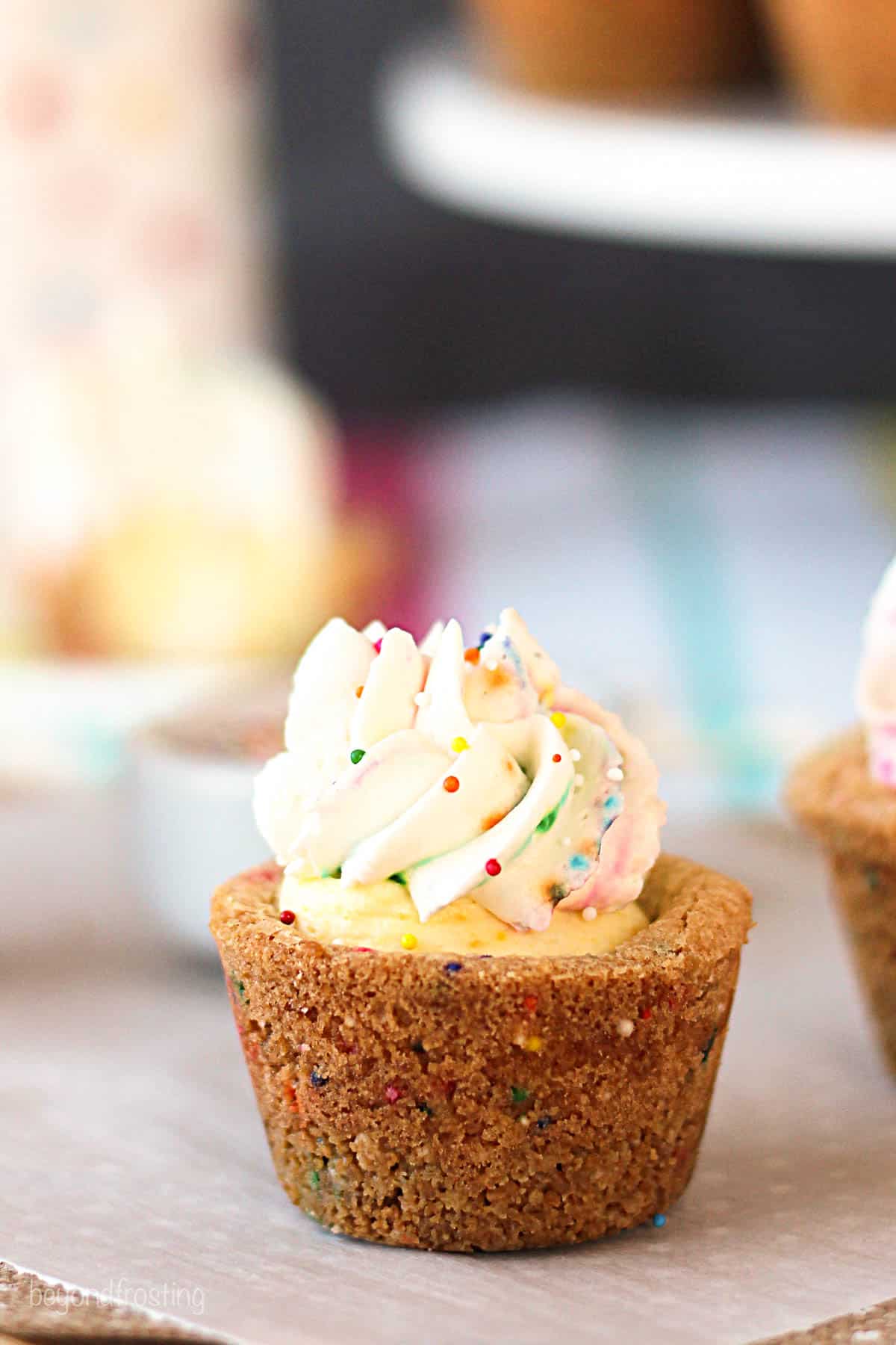 side view of a funfetti cookie cup topped with frosting