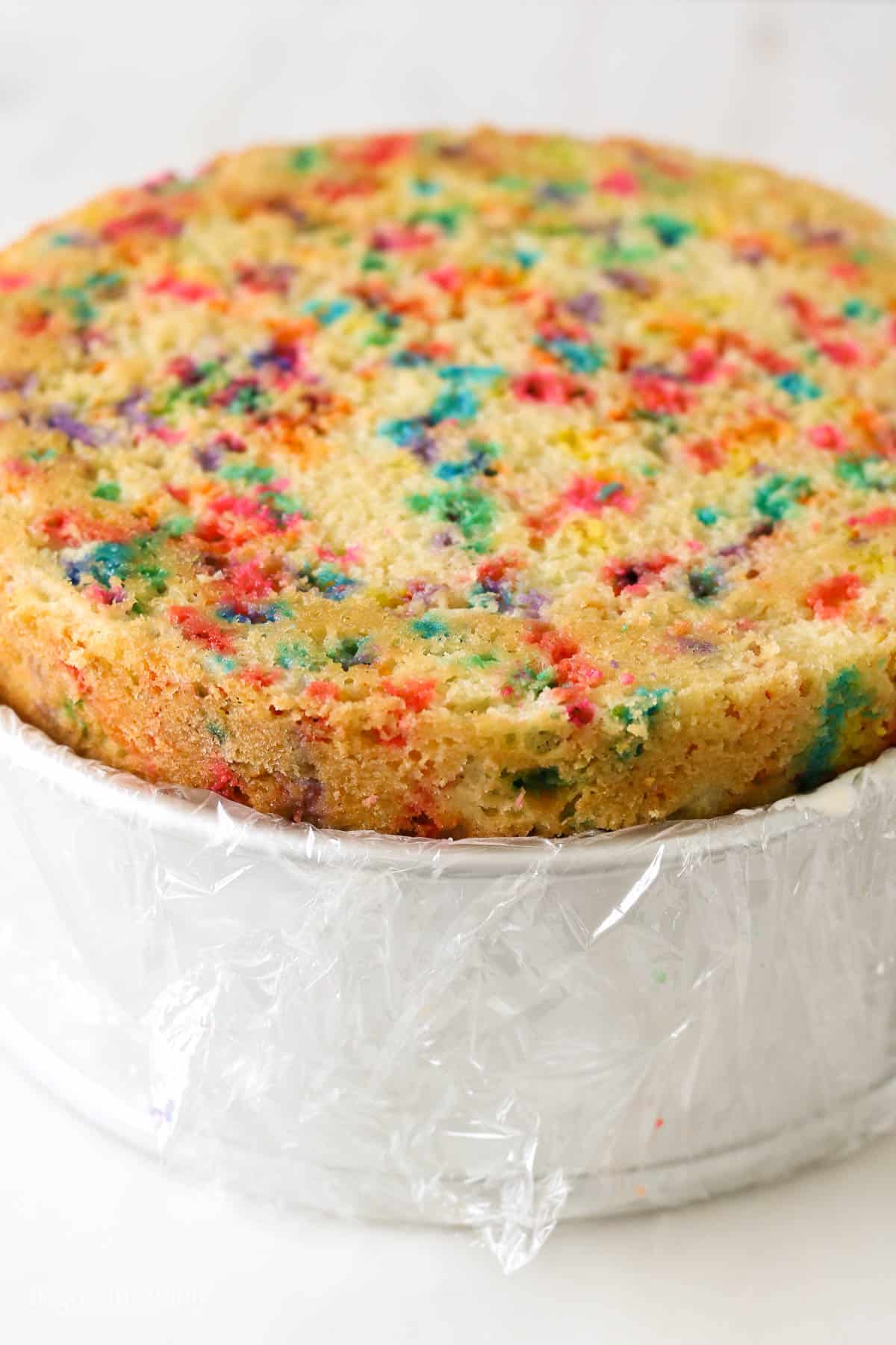 A layer of funfetti cake in a cake pan