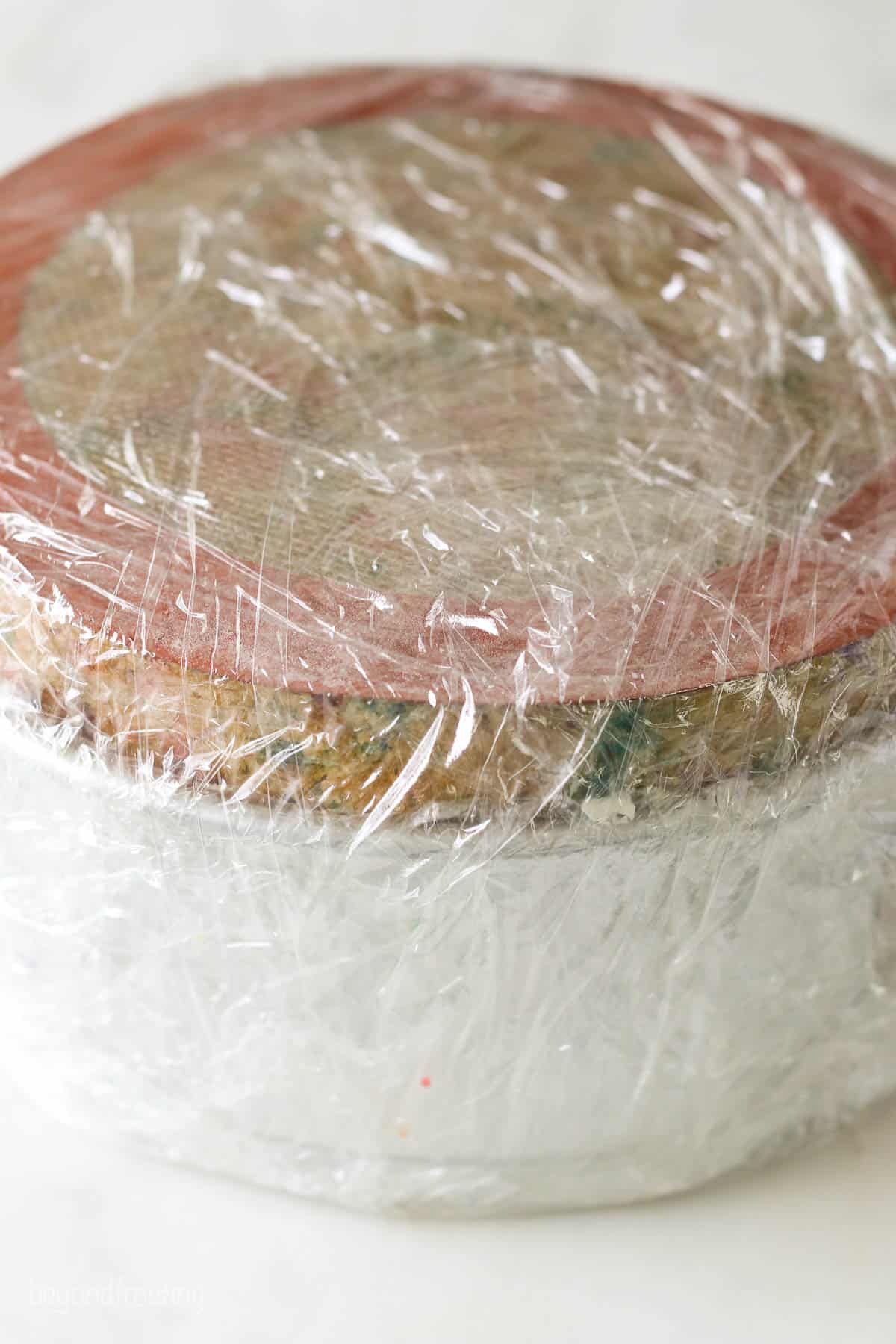 A cake pan wrapped in plastic