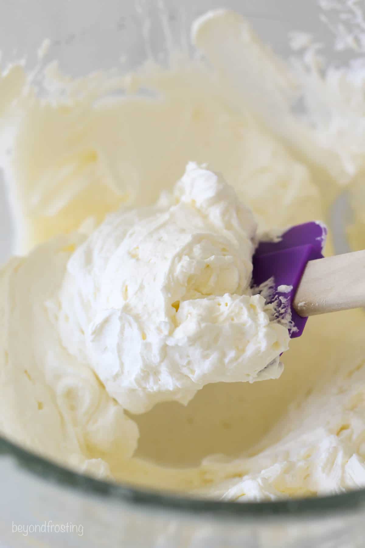 A purple spatula with whipped cream