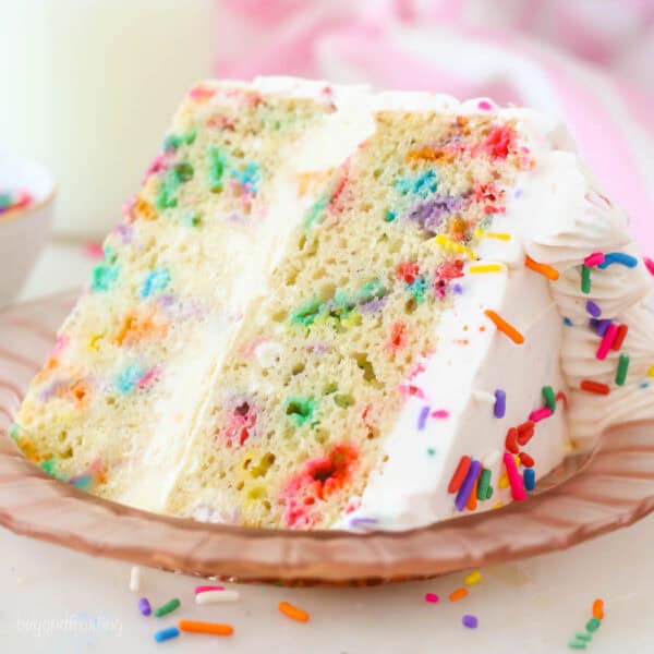 A close up of a slice of Funfetti ice cream cake on a pink plate