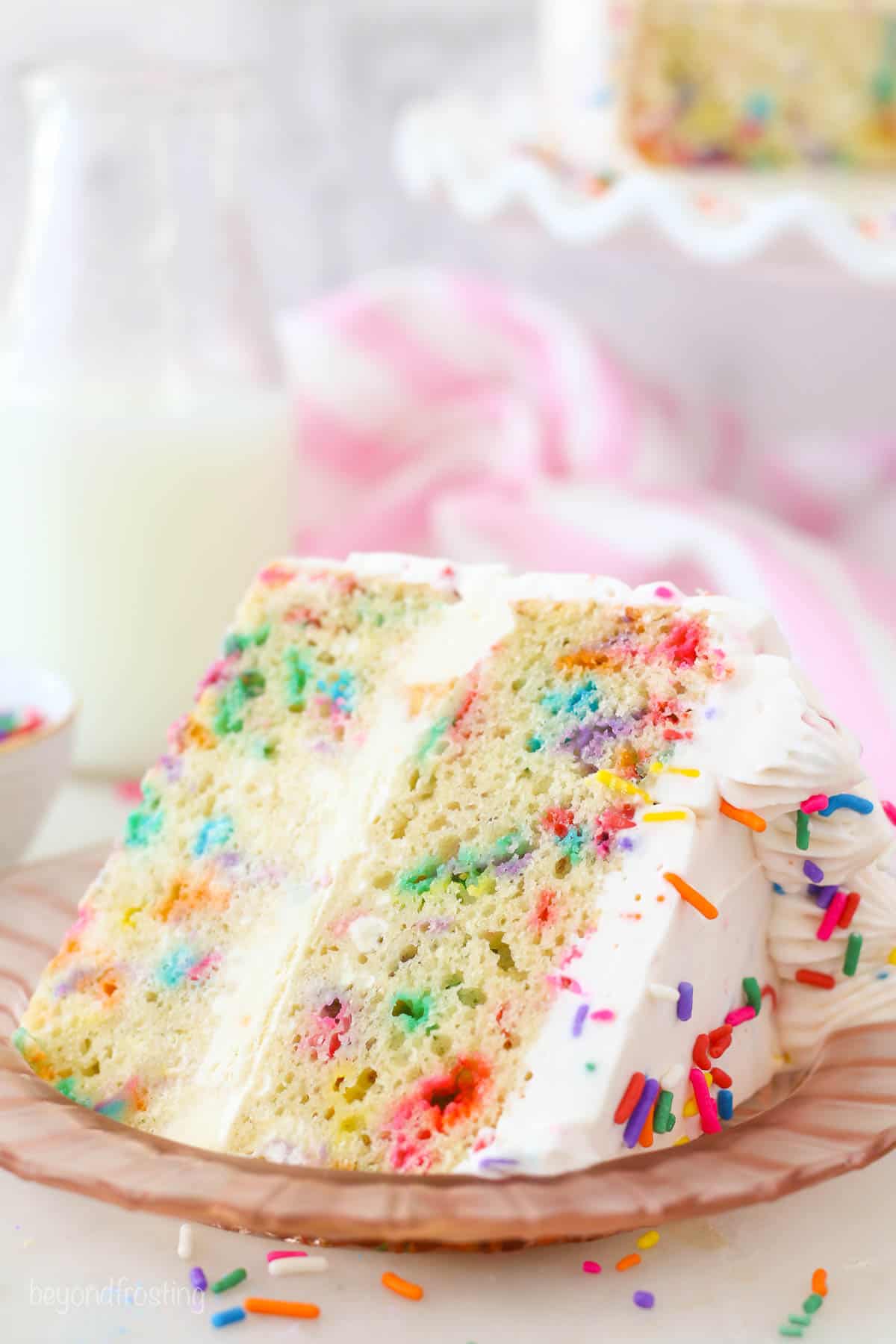 A slice of Funfetti ice cream cake on a pink plate