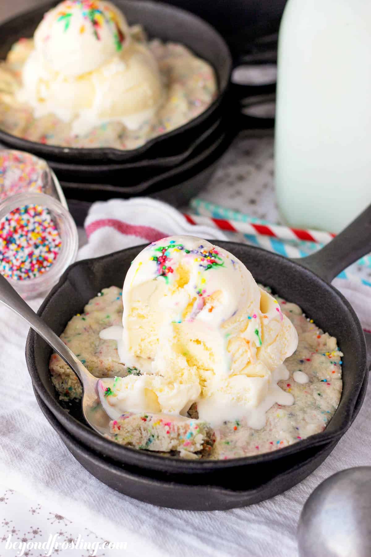 overhead of a partially eaten cookie in a skillet topped with ice cream