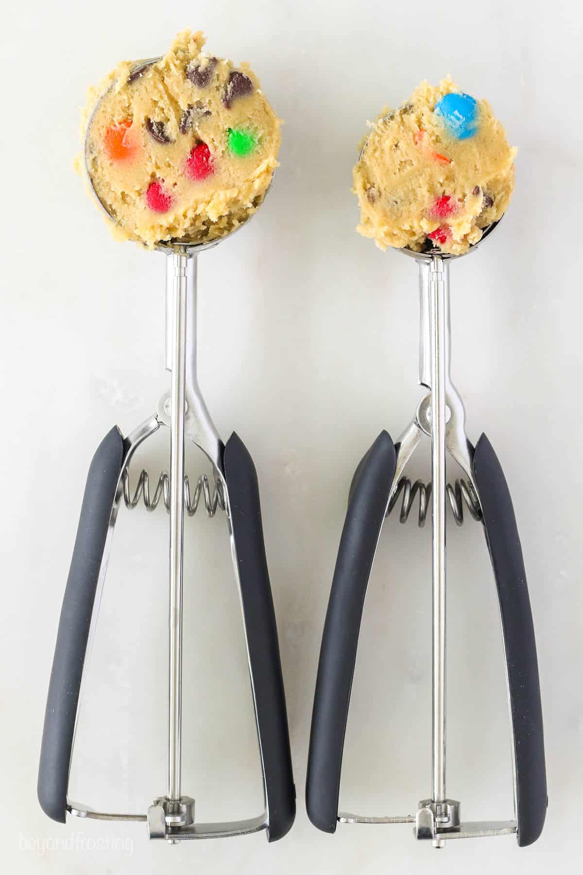 Medium and large cookie scoops of dough