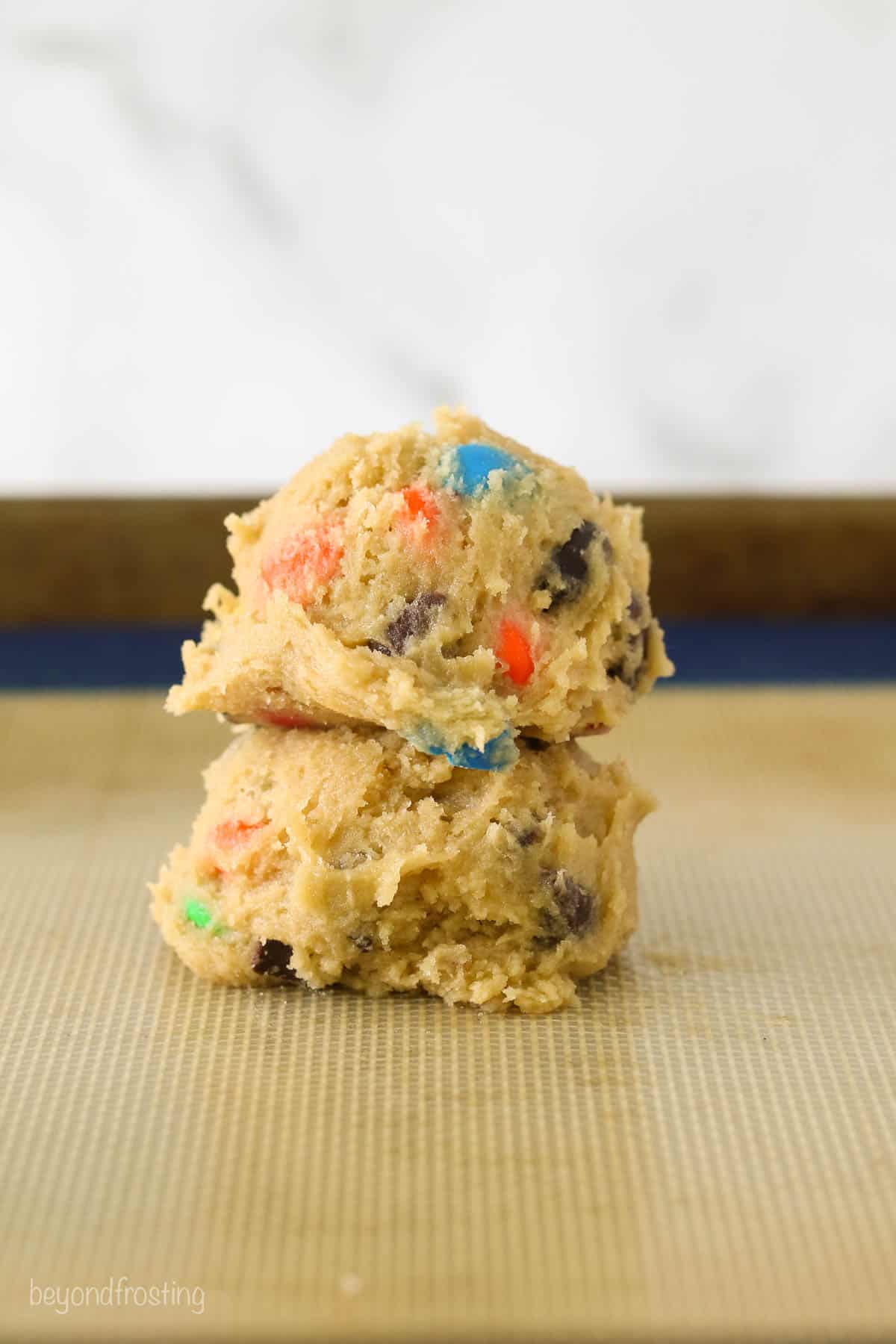 Two balls of M&M cookie dough stacked on each other