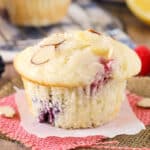 closeup of a lemon raspberry muffin topped with sliced almonds