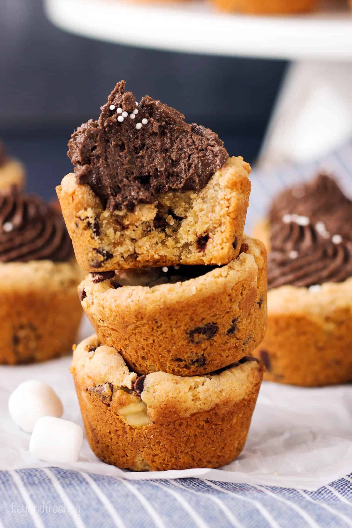 three cookie cups stacked with chocolate frosting on the top