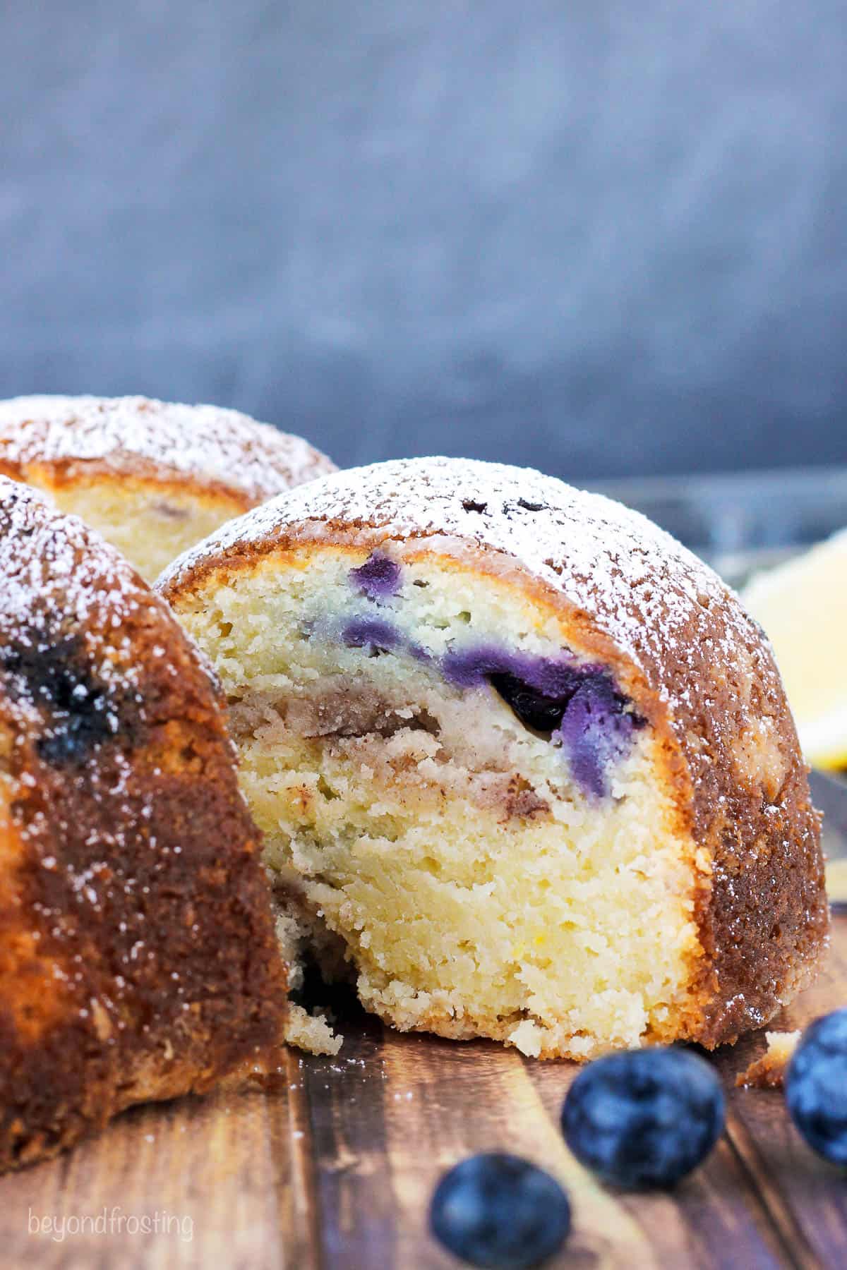 side view of a slice of lemon blueberry bundt cake pulled out of a whole cake