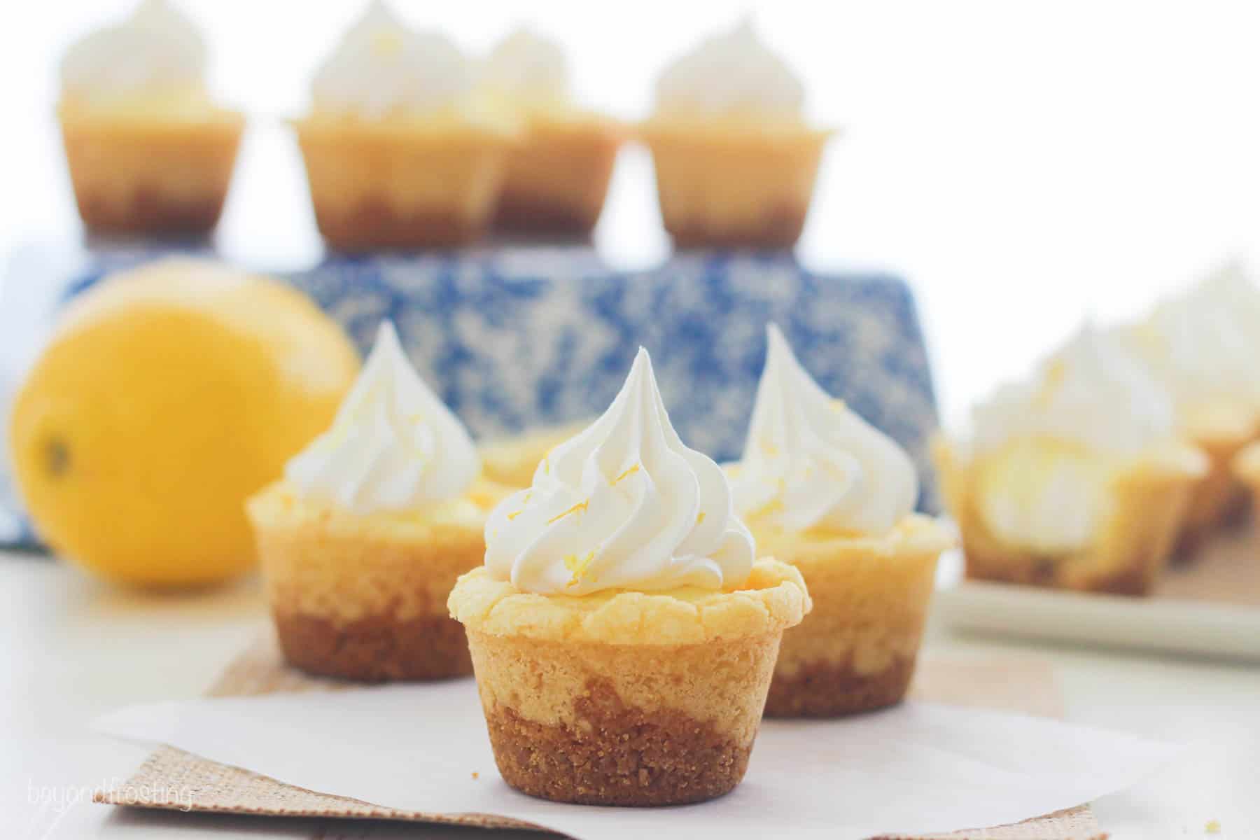 three staggered lemon cream pie cookie cups from the side with more in the background