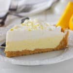closeup side view of a slice of ice cream pie topped with lemon zest