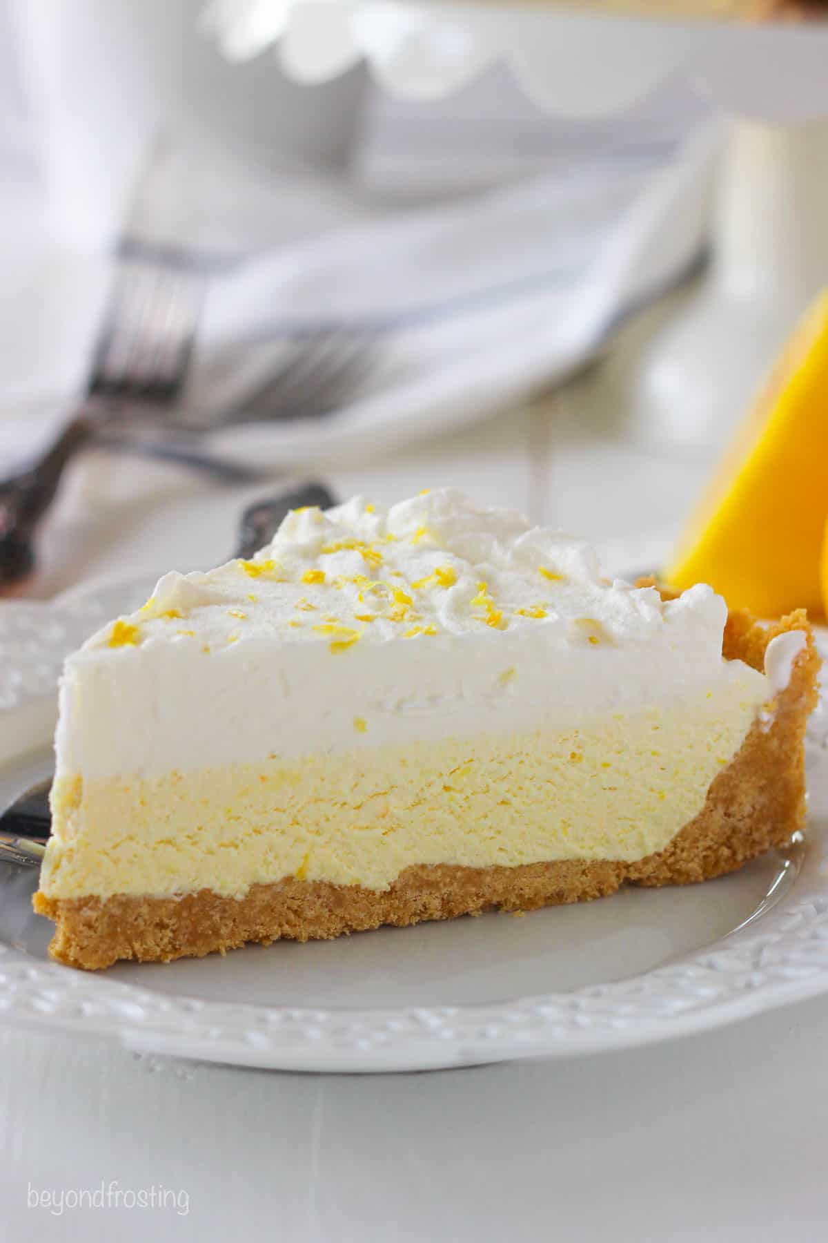 side view of a slice of lemon icebox pie on a white plate