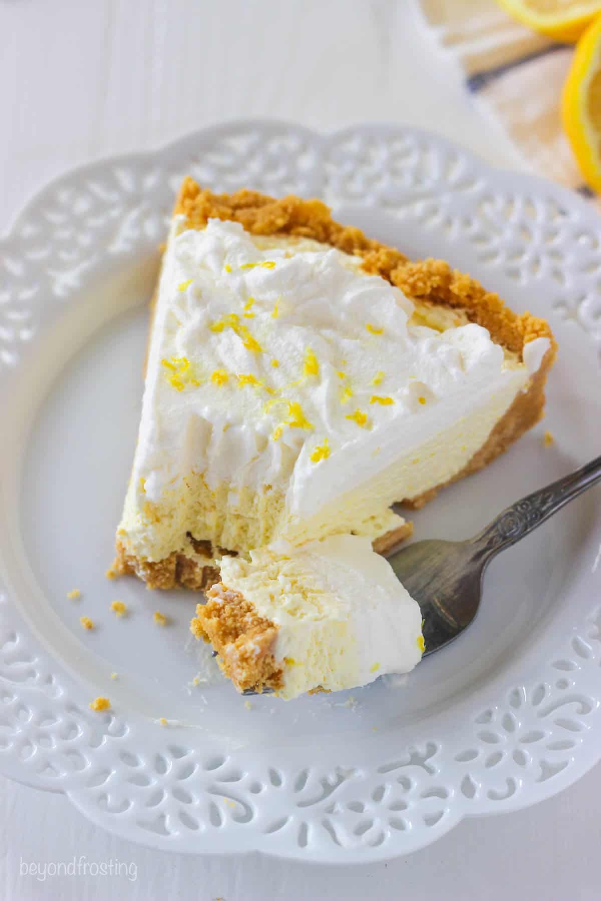 overhead of a partially eaten slice of lemon ice cream pie with a bite on a fork