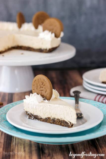 side view of a slice of gingerbread cheesecake on a plate garnished with a gingerbread cookie