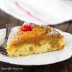 side view of a slice of pineapple upside down cake topped with a maraschino cherry