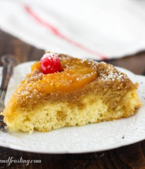 side view of a slice of pineapple upside down cake topped with a maraschino cherry