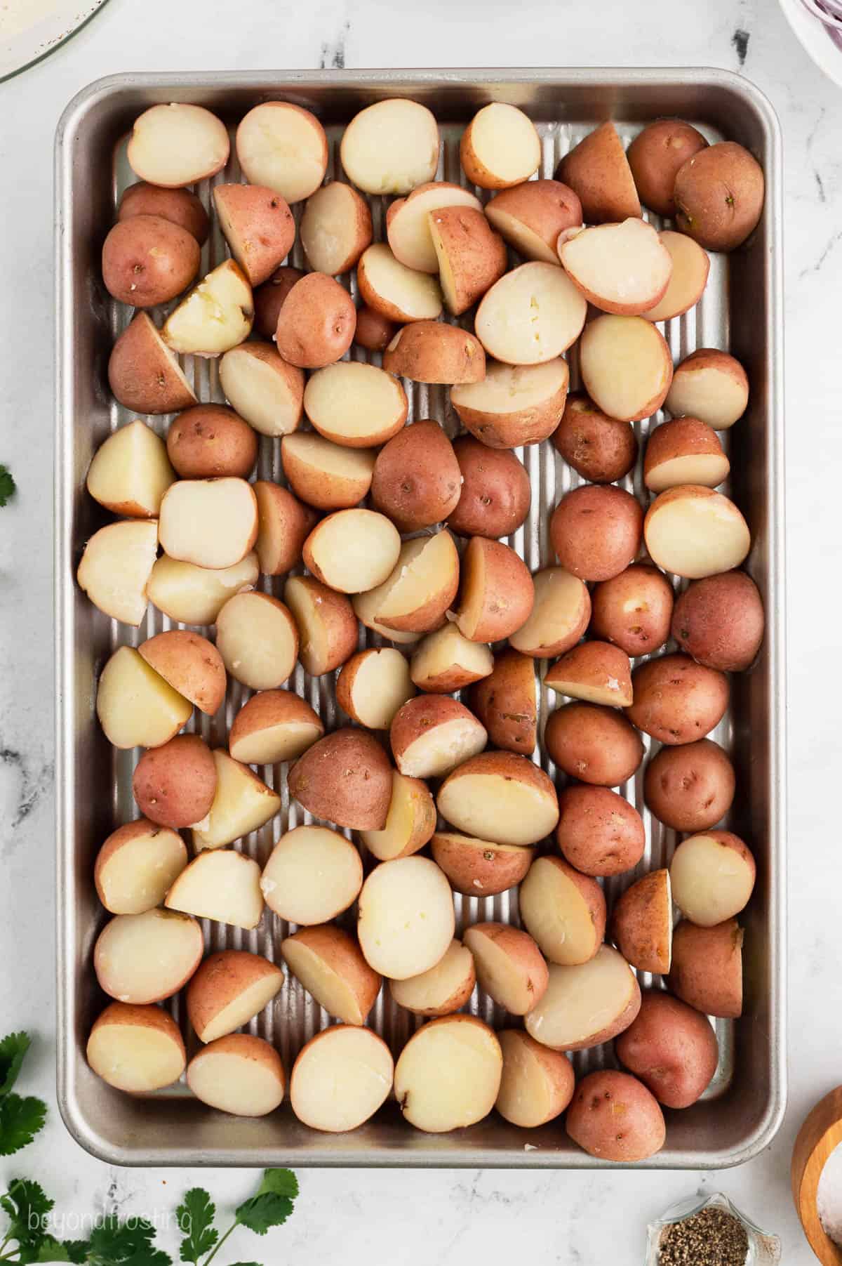 Halves red potatoes on a baking sheet