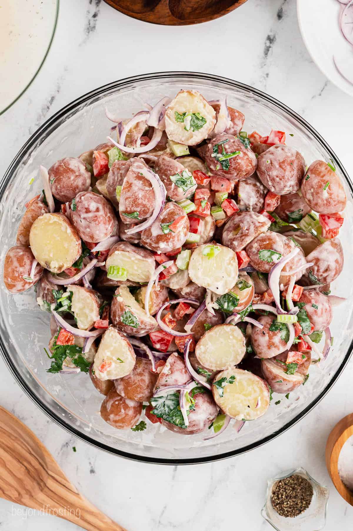 Overhead view of red potato salad in a mixing bowl