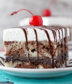 closeup side view of a slice of vanilla and chocolate marbled cake topped with a cherry