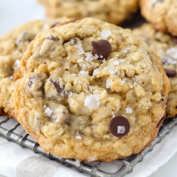 closeup of a salted caramel oatmeal cookie on a cooling rack garnished with flakey sea salt