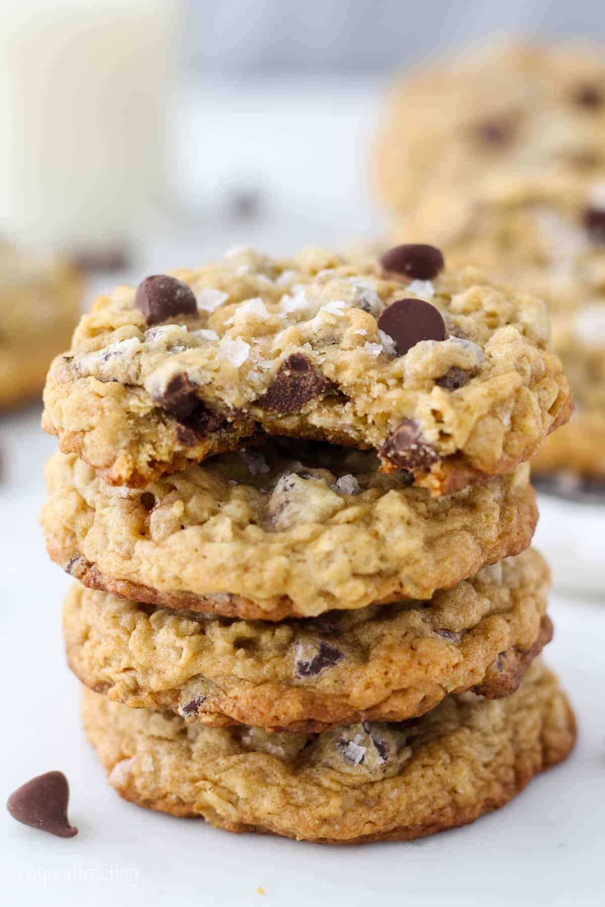 four oatmeal cookies stacked with a bite out of the top cookie