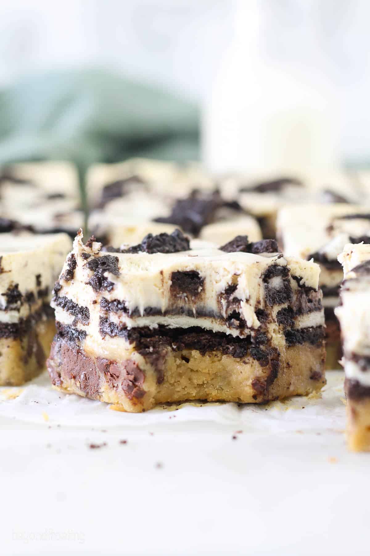 a layered cheesecake bar with a bite missing