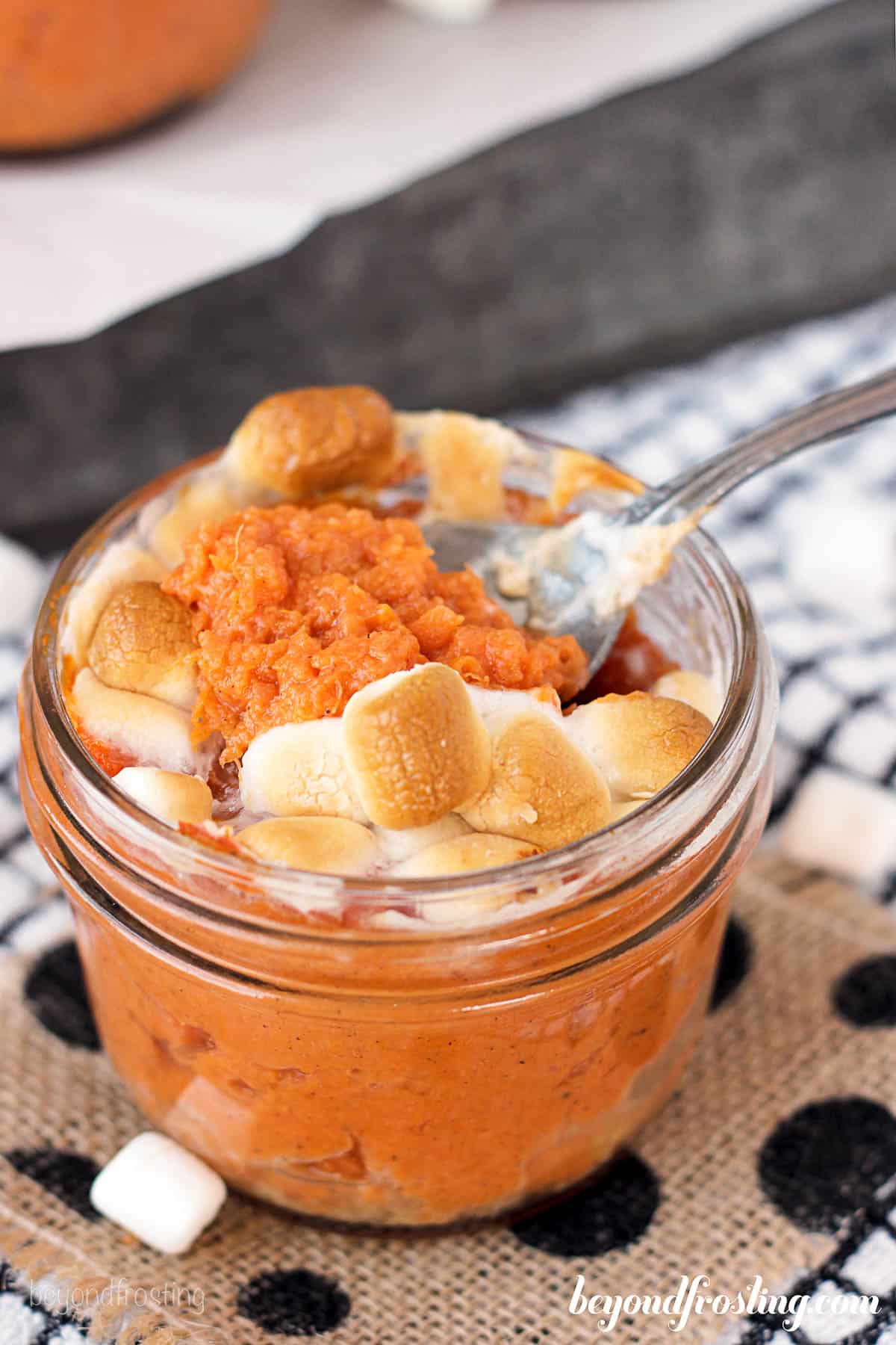 overhead of a jar filled with sweet potato and marshmallow with a spoon