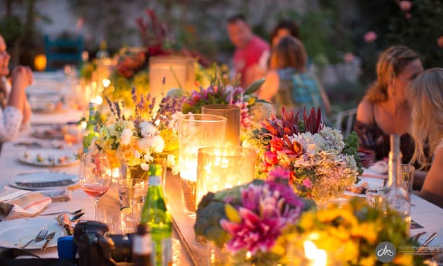 Close-up of fresh flowers and candles at the center of an outdoor dining table