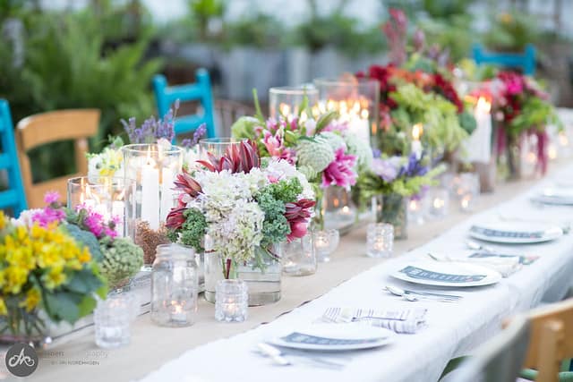 Close-up view of floral arrangement centerpieces on a long outdoor table