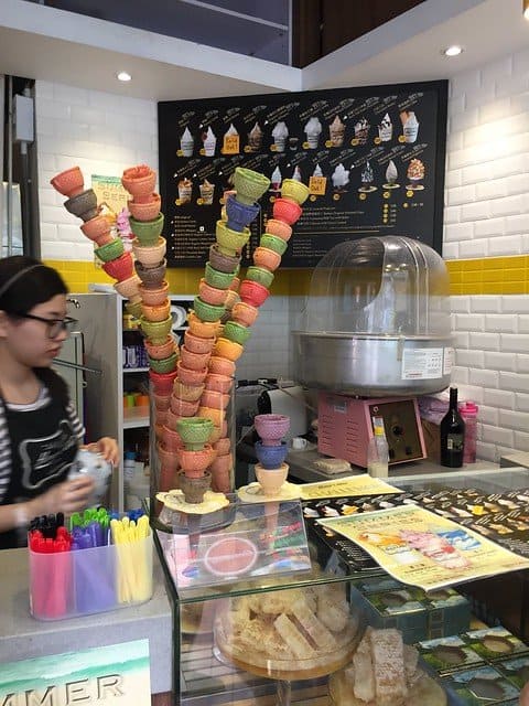 Inside an ice cream shop with stacks of multi-colored cones