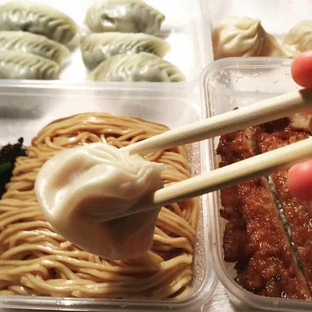 Close-up of dumplings and noodles with chopsticks