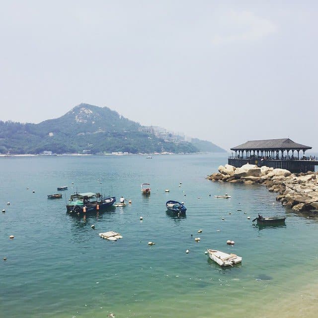 Boats in the water with a mountain behind at Hong Kong island