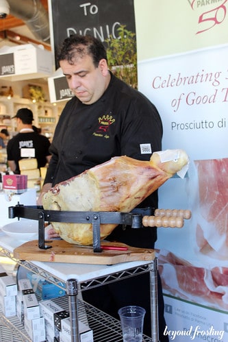 A chef with a proscuitto in a rack