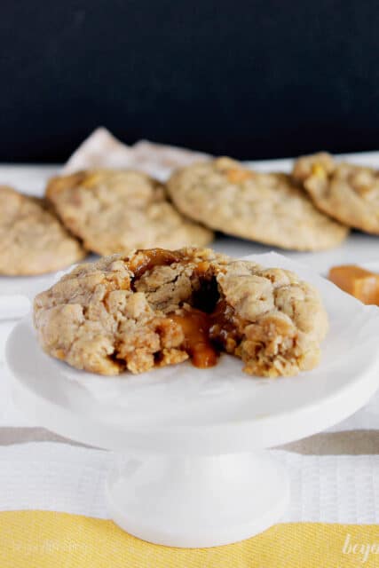 side view of a cupcake stand topped with an oatmeal cookie with caramel dripping out